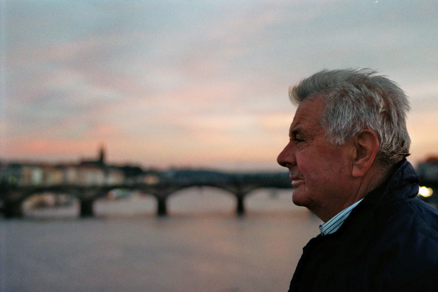 Prague man looking at the infinite Vtlava river sunset