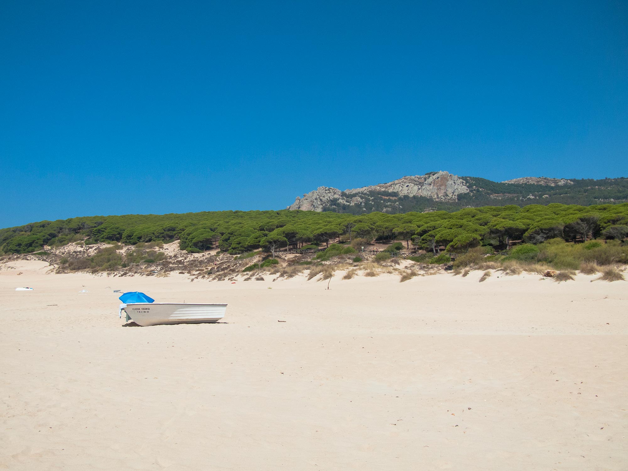 Bolonia beach boat and blue umbrella