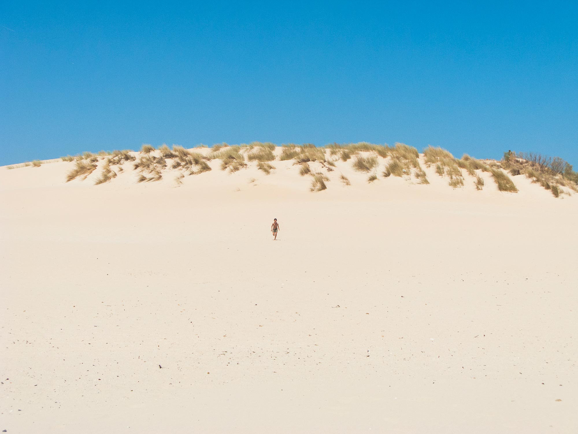 valdevaqueros beach kid running on a dune